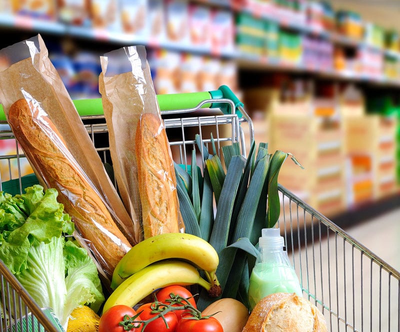 Einkaufswagen gefüllt mit gesunden Lebensmitteln und Früchten